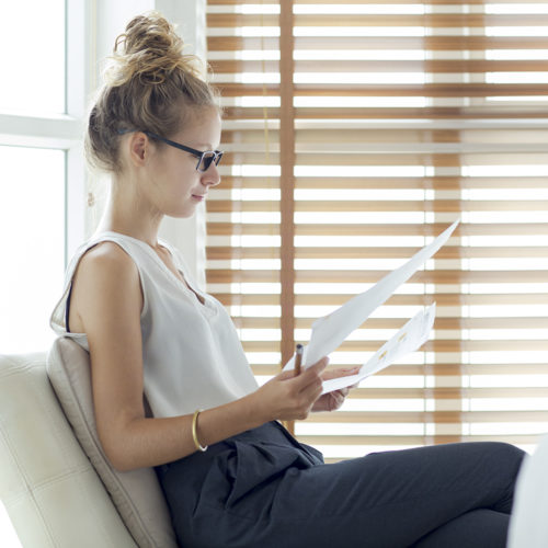 Serious young businesswoman working with papers